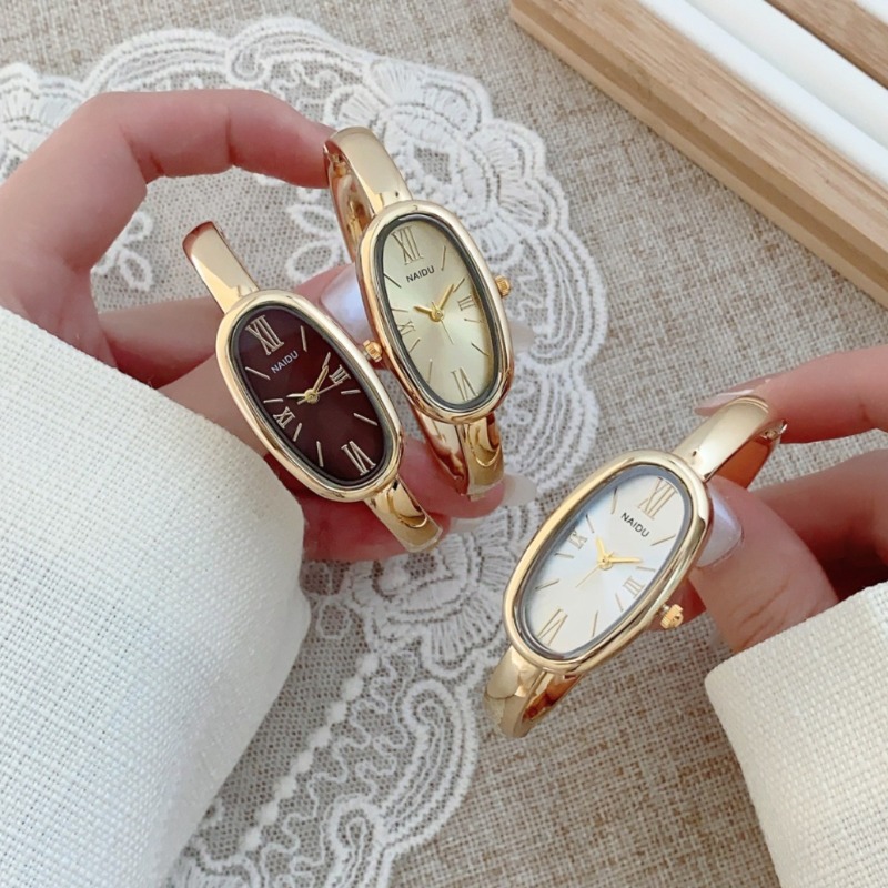 Luxury Watch Cartier - นาฬิกาข้อมือควอตซ์ทรงรี หน้าปัดโรมัน แบรนด์ดังสำหรับผู้หญิง ดีไซน์เรียบหรู สีทอง พร้อมสายแบบกำไลข้อมือ